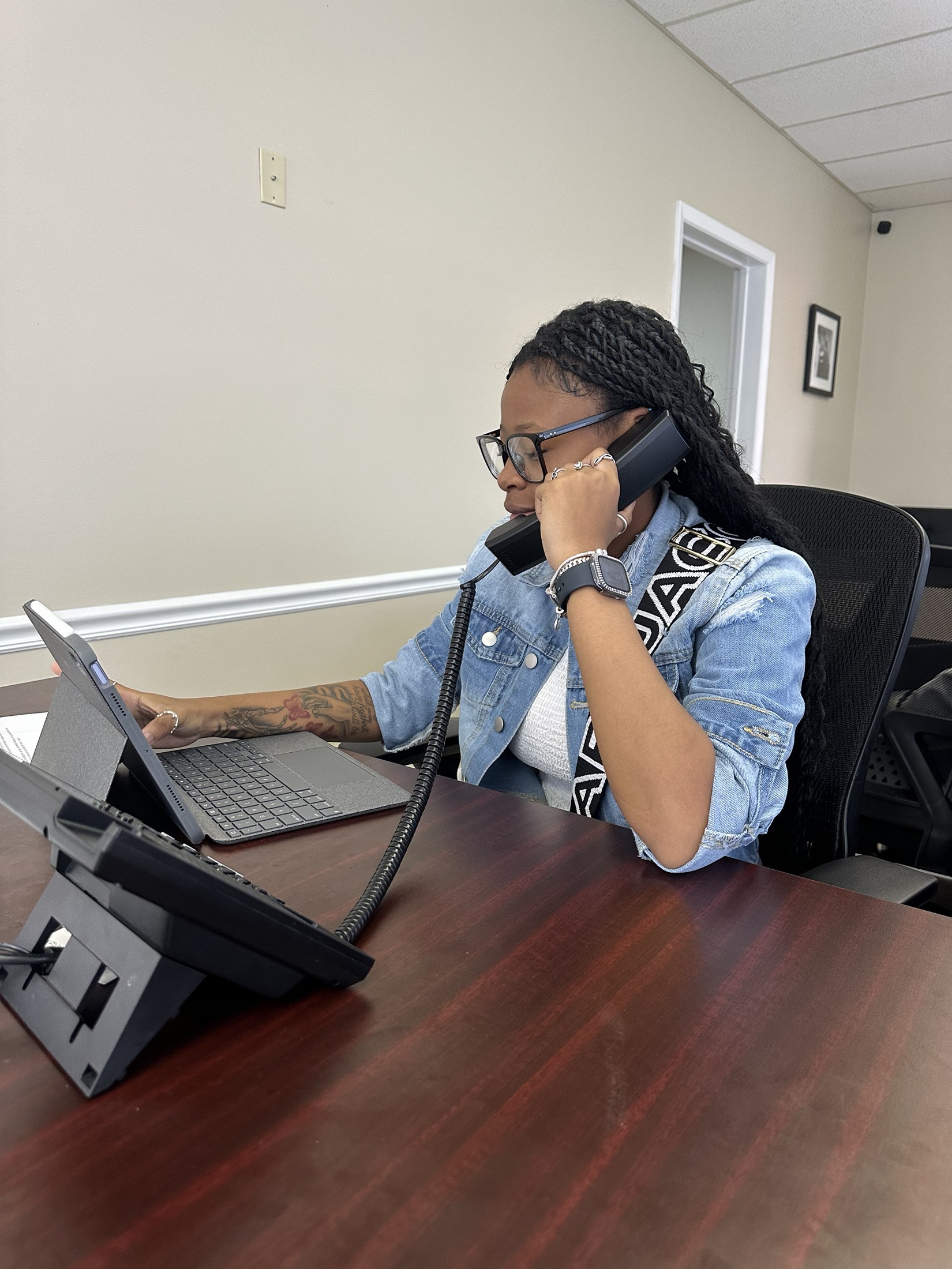 A young participant working at a desk while taking a call.