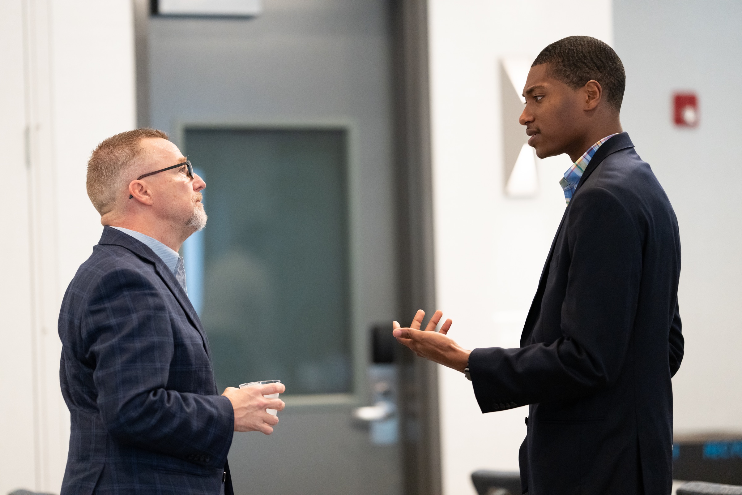 Two people in conversation during a formal community event.